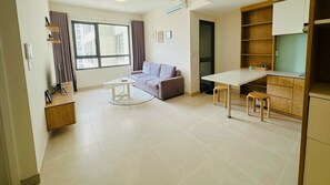 Een modern appartement met een zithoek, een eettafel en een kitchenette.