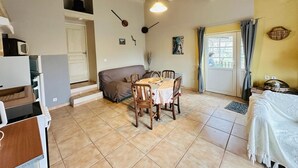 A cozy living room with a dining table, sofa, and kitchen area. - Propriété en pleine nature   (Beynes)