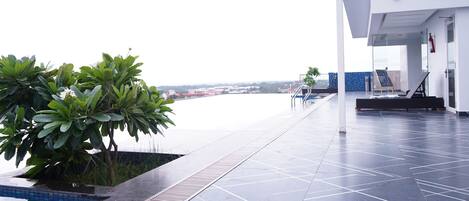 Un área de piscina moderna en la azotea con vistas al horizonte de la ciudad.