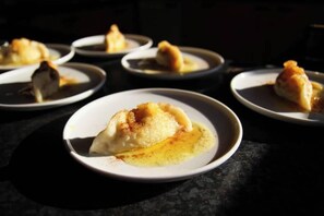 Een reeks borden met dumplings op een donker oppervlak.