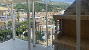 A balcony with a view of a residential area and a mountain. - Nonna's Hill House (Corfu)