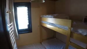 A bunk bed room with a window, a ceiling lamp, and a radiator. - Studio for 4 with balcony, pets allowed and parking (Châtel)