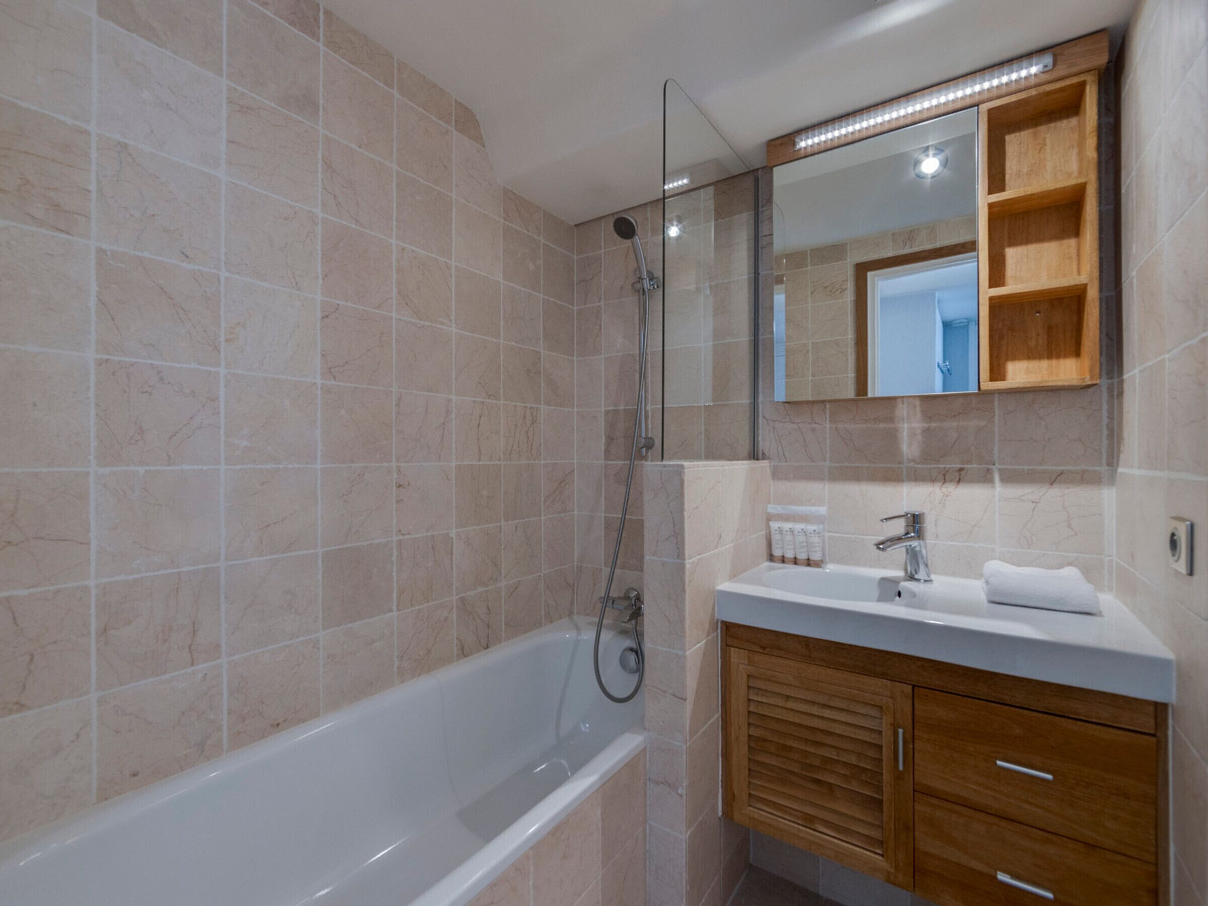 Une salle de bain avec une baignoire, une douche, un lavabo et un miroir.