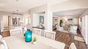A spacious living area with a dining table, chairs, and a kitchen in the background. - Punta Gorda Isles waterfront pool home (Punta Gorda)