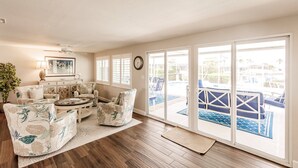 A spacious living room with a large sliding glass door leading to a pool area. - Punta Gorda Isles waterfront pool home (Punta Gorda)