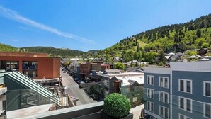 A residential area with buildings, a clear sky, and a hill in the background. - Park Haus on Main Street in Historic Old Town (Park City)