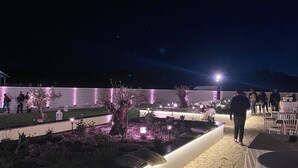 An outdoor event space with a paved walkway, illuminated plants, and tables set up for guests. - Bahal dell Etna (Ramacca)