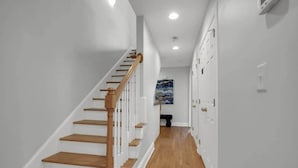 A narrow hallway with wooden stairs leading to a landing. - Lakefront Beautiful Townhome w/ Stunning Views! (North Charleston)