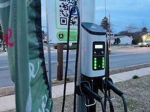 Eine Ladestation mit digitalem Display und einem QR-Code auf einem Schild.
