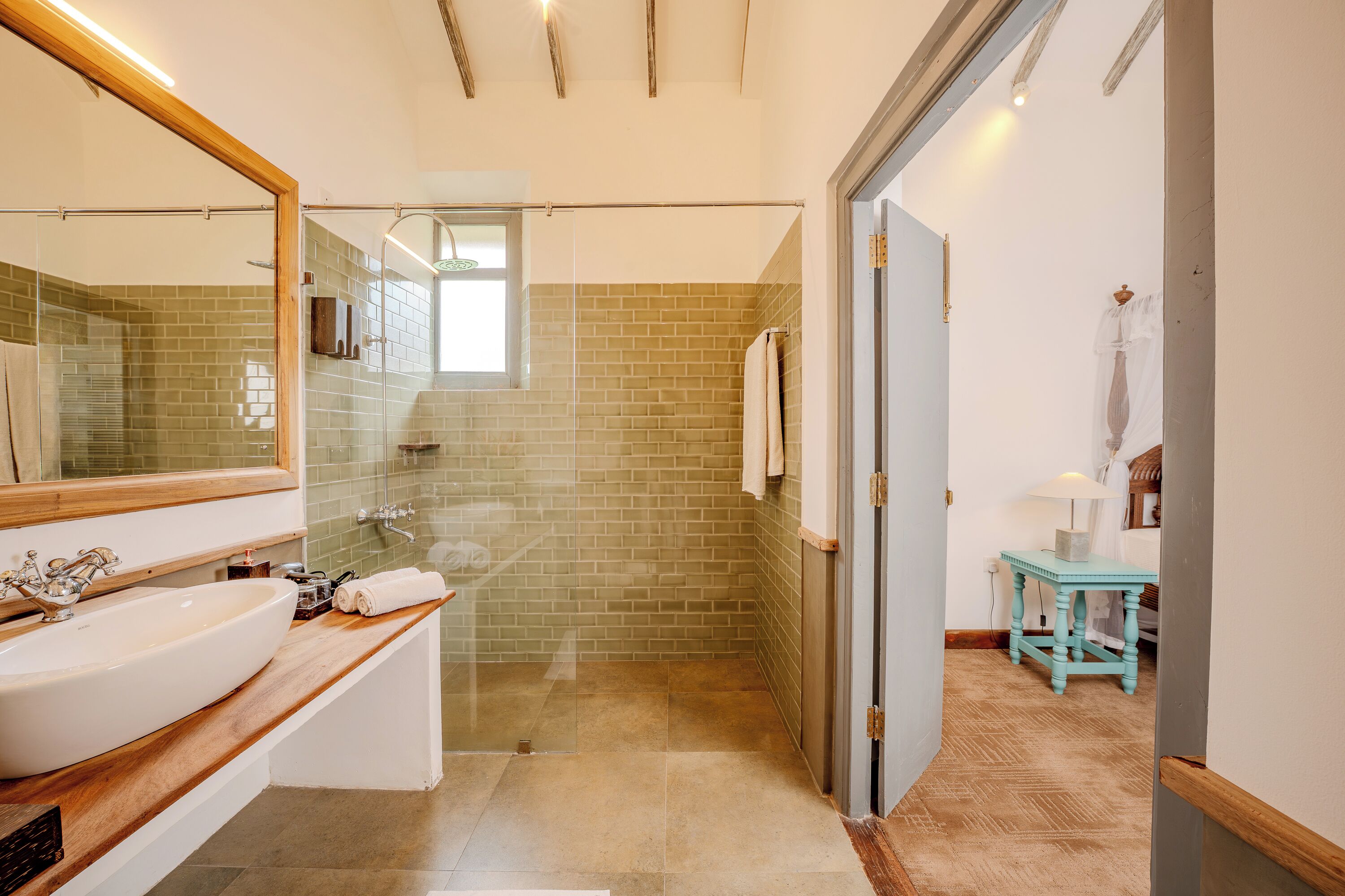 A modern bathroom with a large sink, mirror, and shower area.