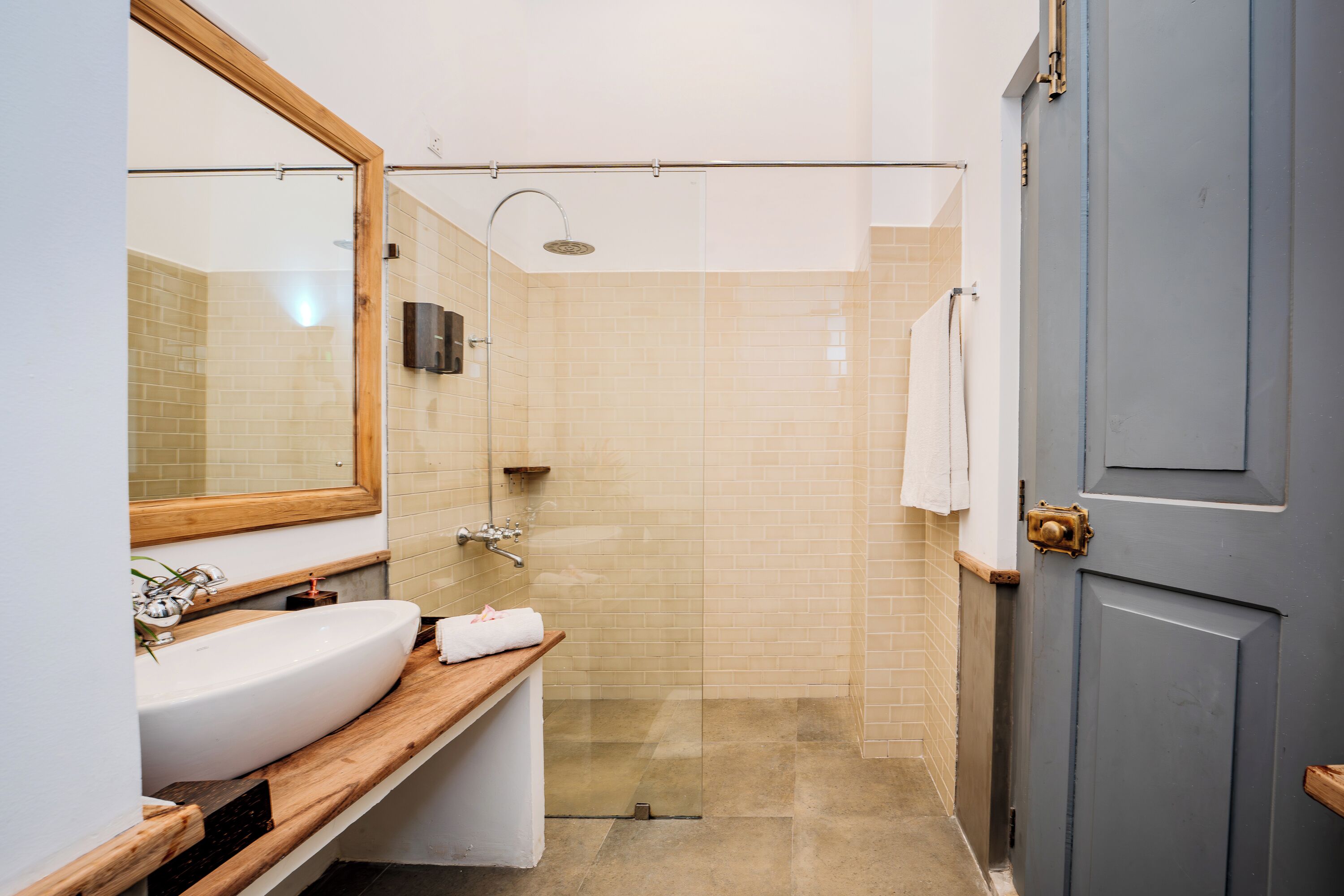 A modern bathroom with a large sink, mirror, and shower.