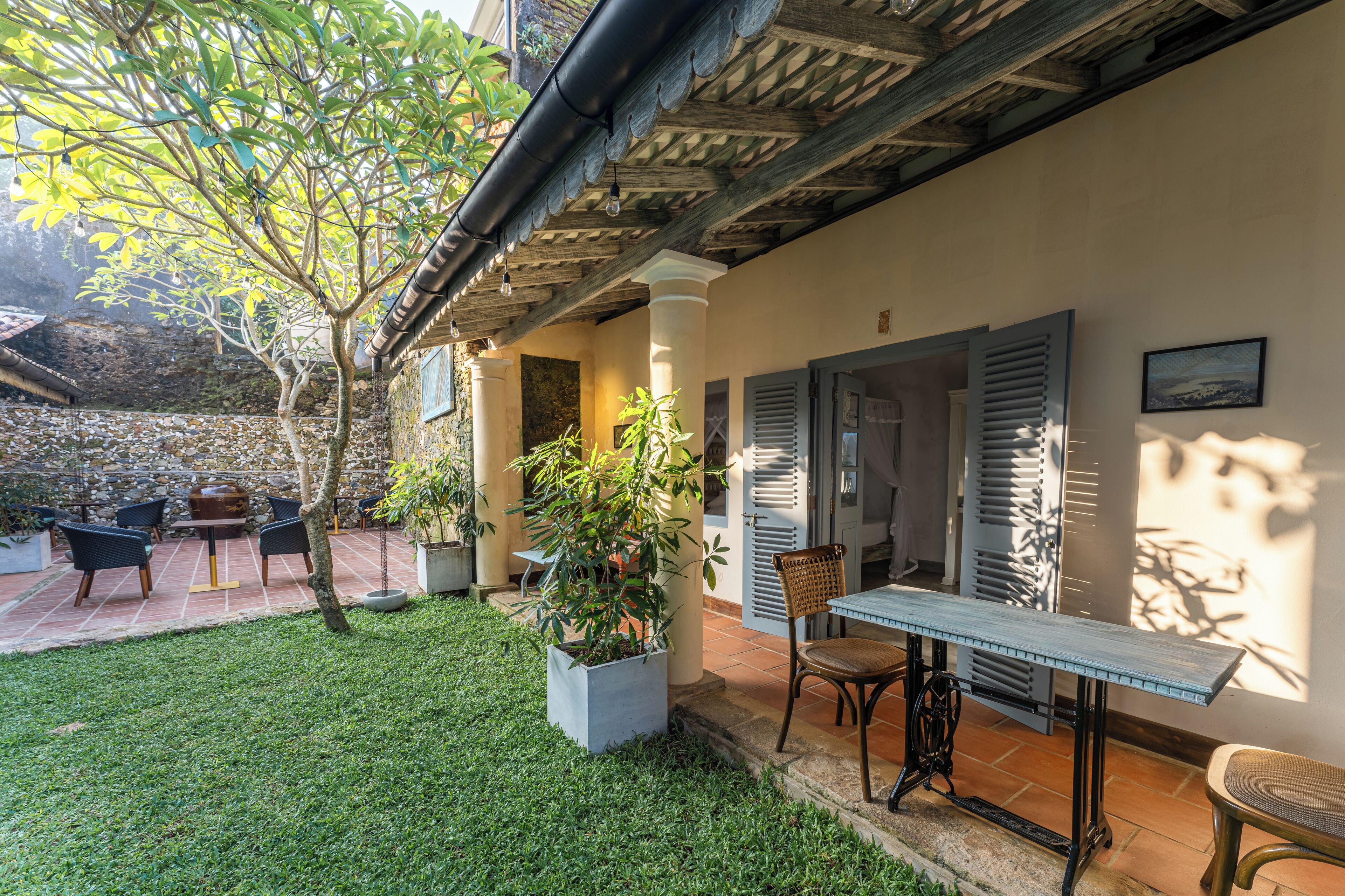 Un patio con una mesa y sillas, una planta en maceta y vistas del entorno.