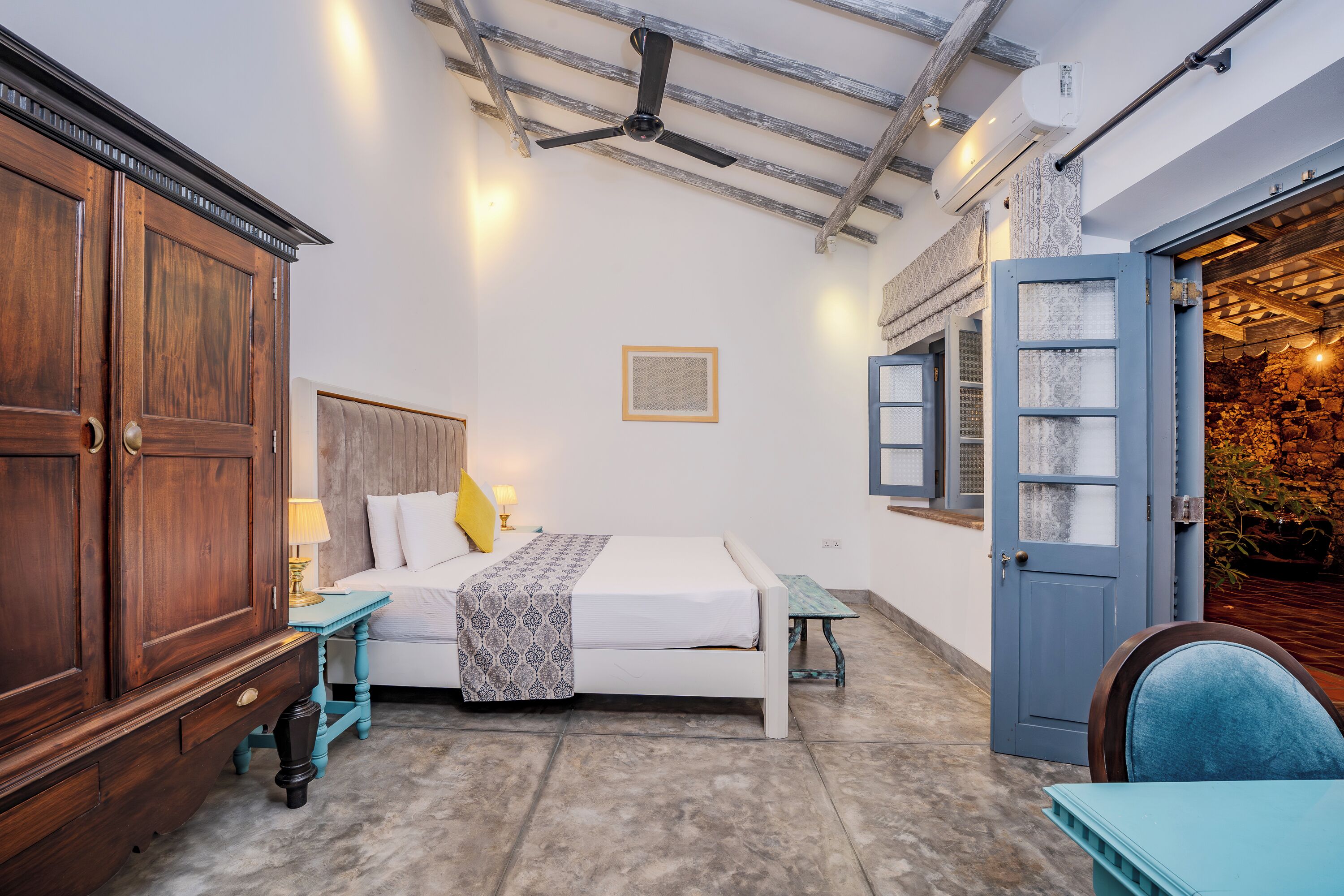 Un dormitorio con cama, mesita de noche, lámpara y armario.