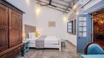 Un dormitorio con cama, mesita de noche, lámpara y armario.