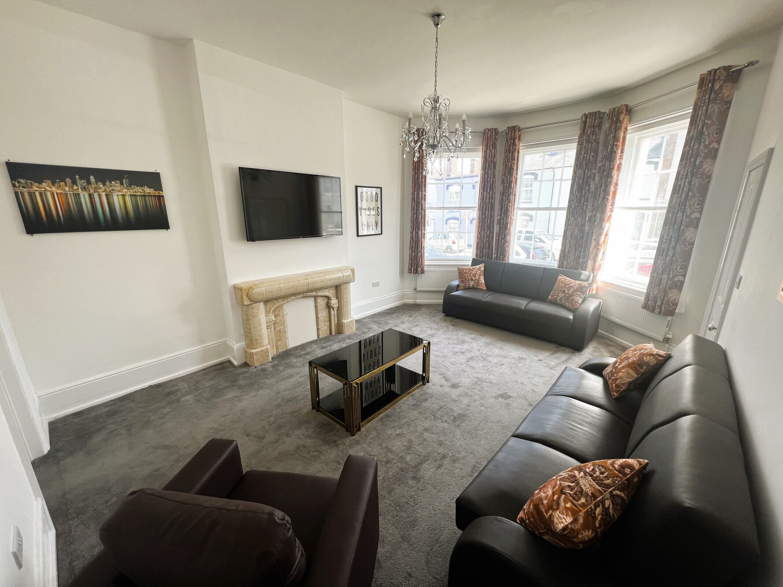 A living room with a fireplace, a sofa, a coffee table, and a TV.