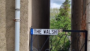 Ein Metalltor mit einem Straßenschild, auf dem 