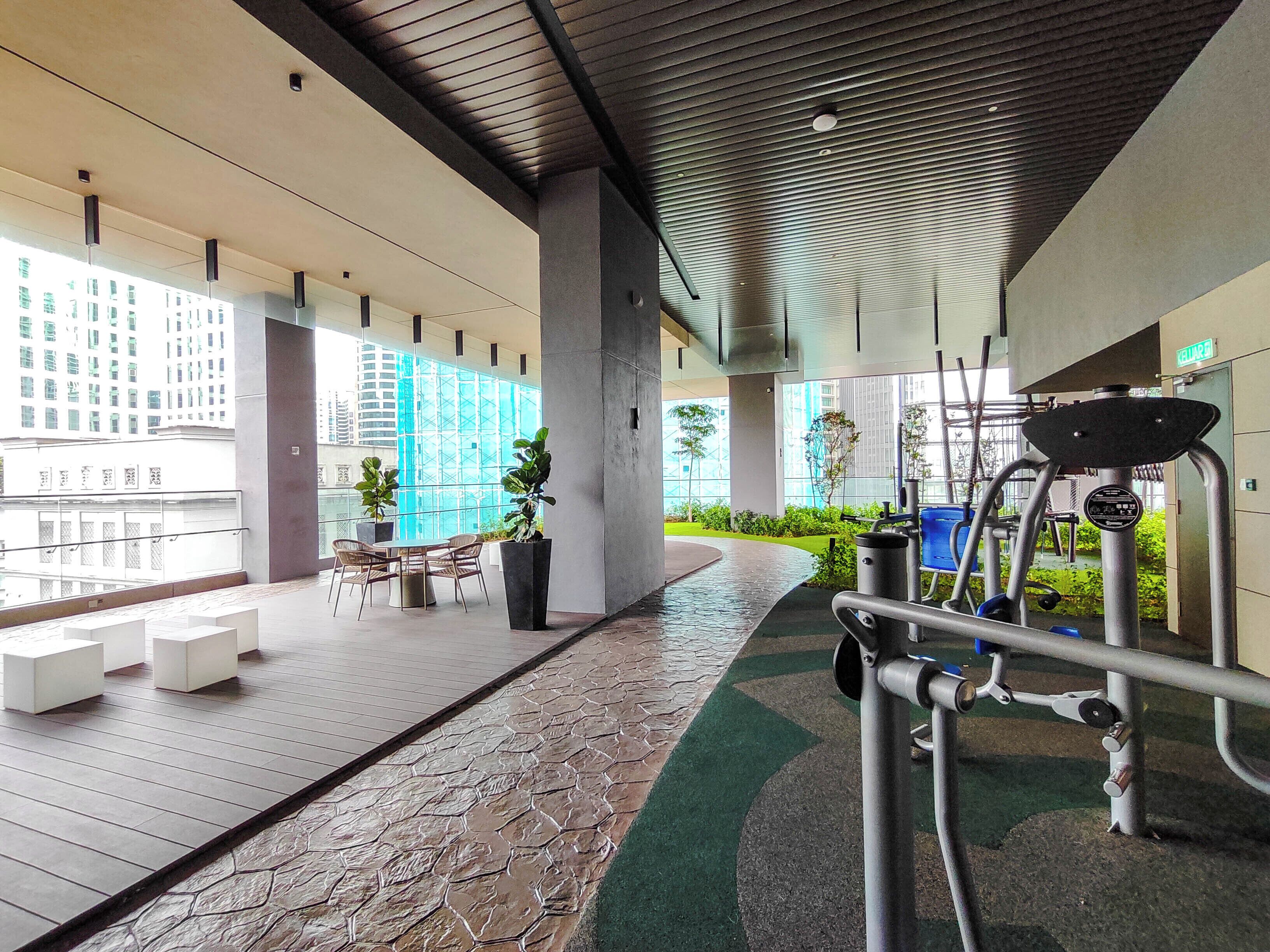 A modern indoor area with a wooden floor, seating area, and exercise equipment.