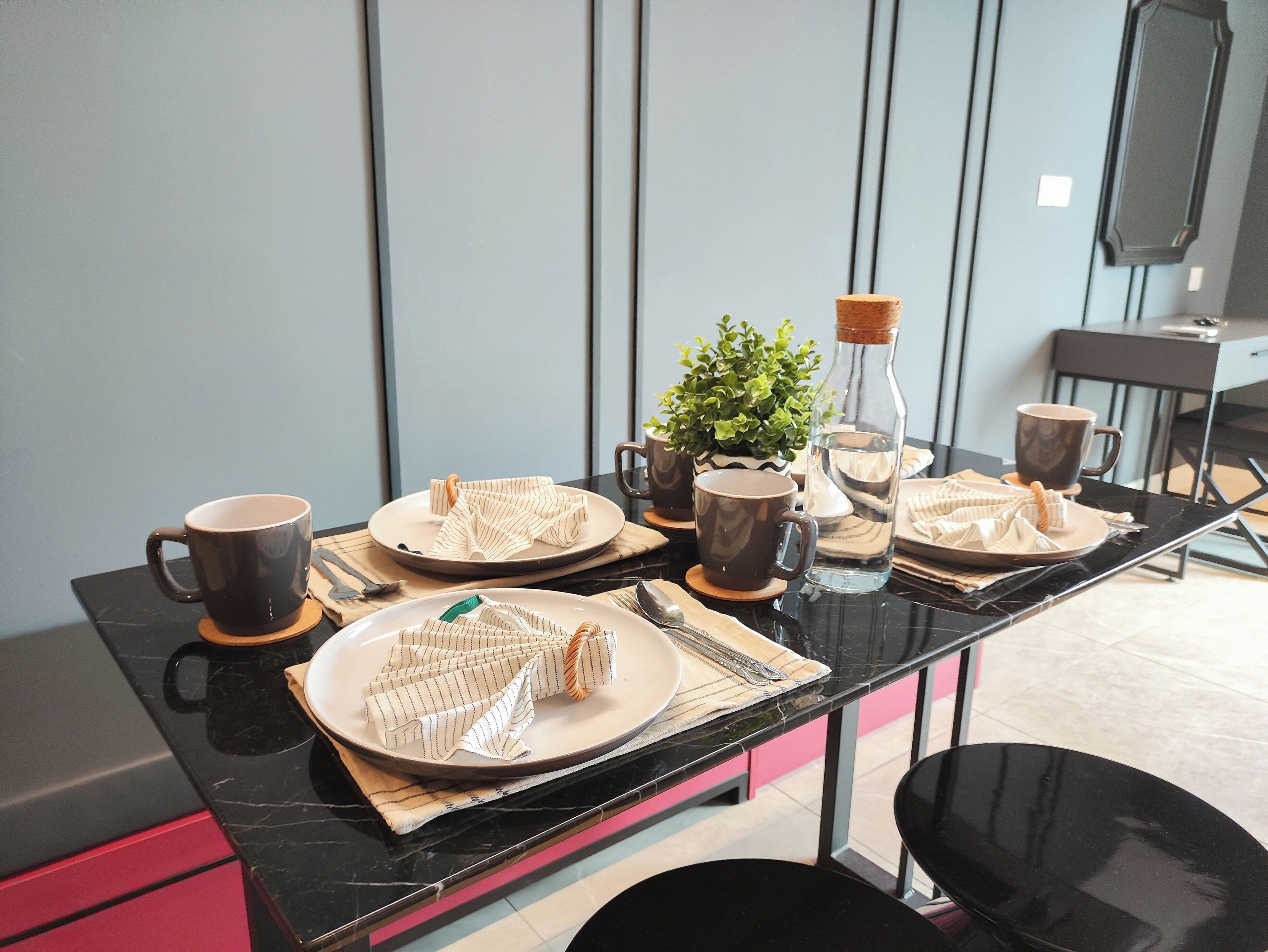 A dining table set with plates, napkins, and cutlery.
