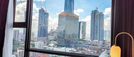 A view from a window of a high-rise building with multiple skyscrapers in the background.