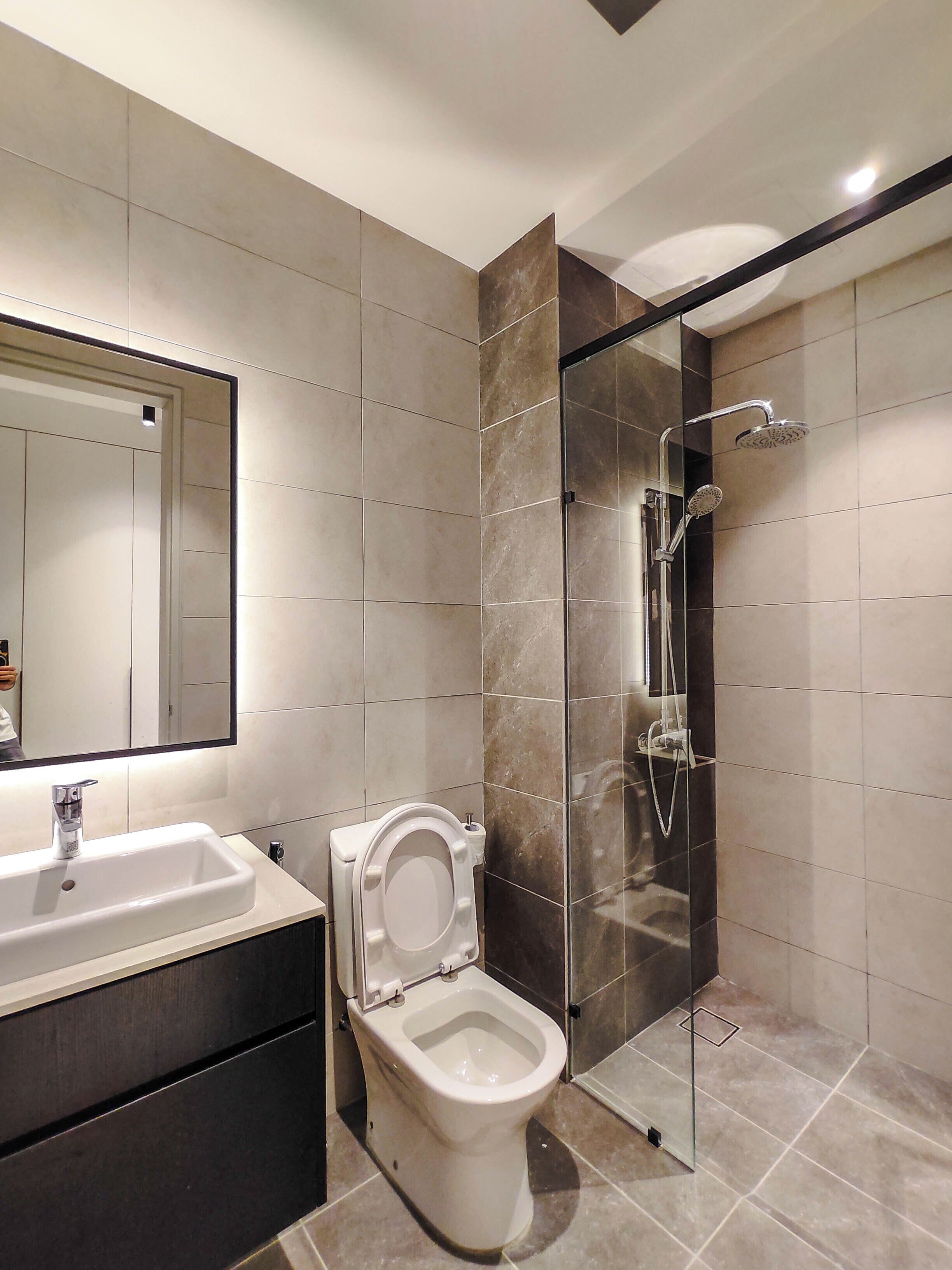 A modern bathroom with a toilet, sink, and shower.