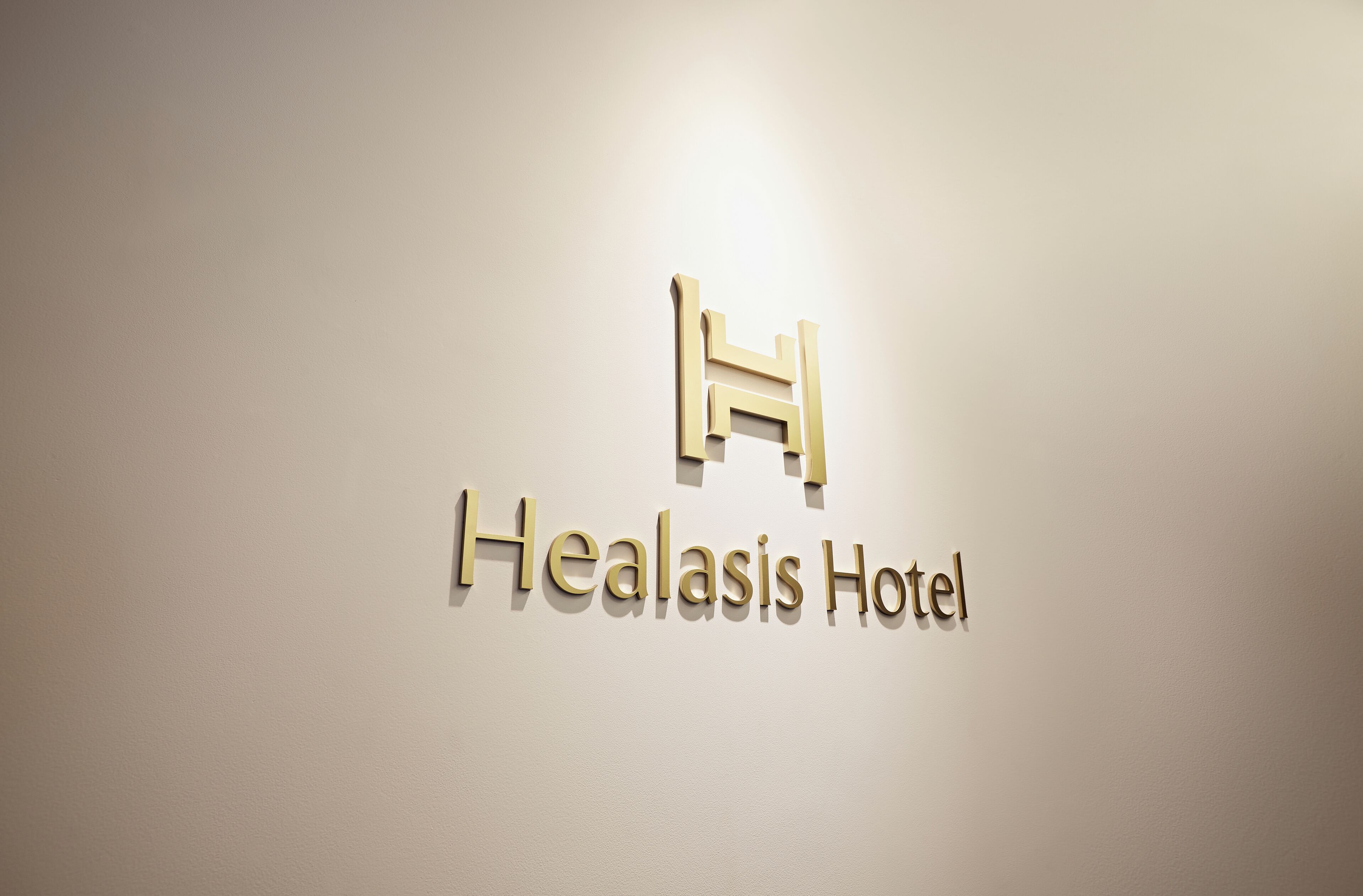 Señal del Hotel Healasis con un logotipo estilizado de 'H'.
