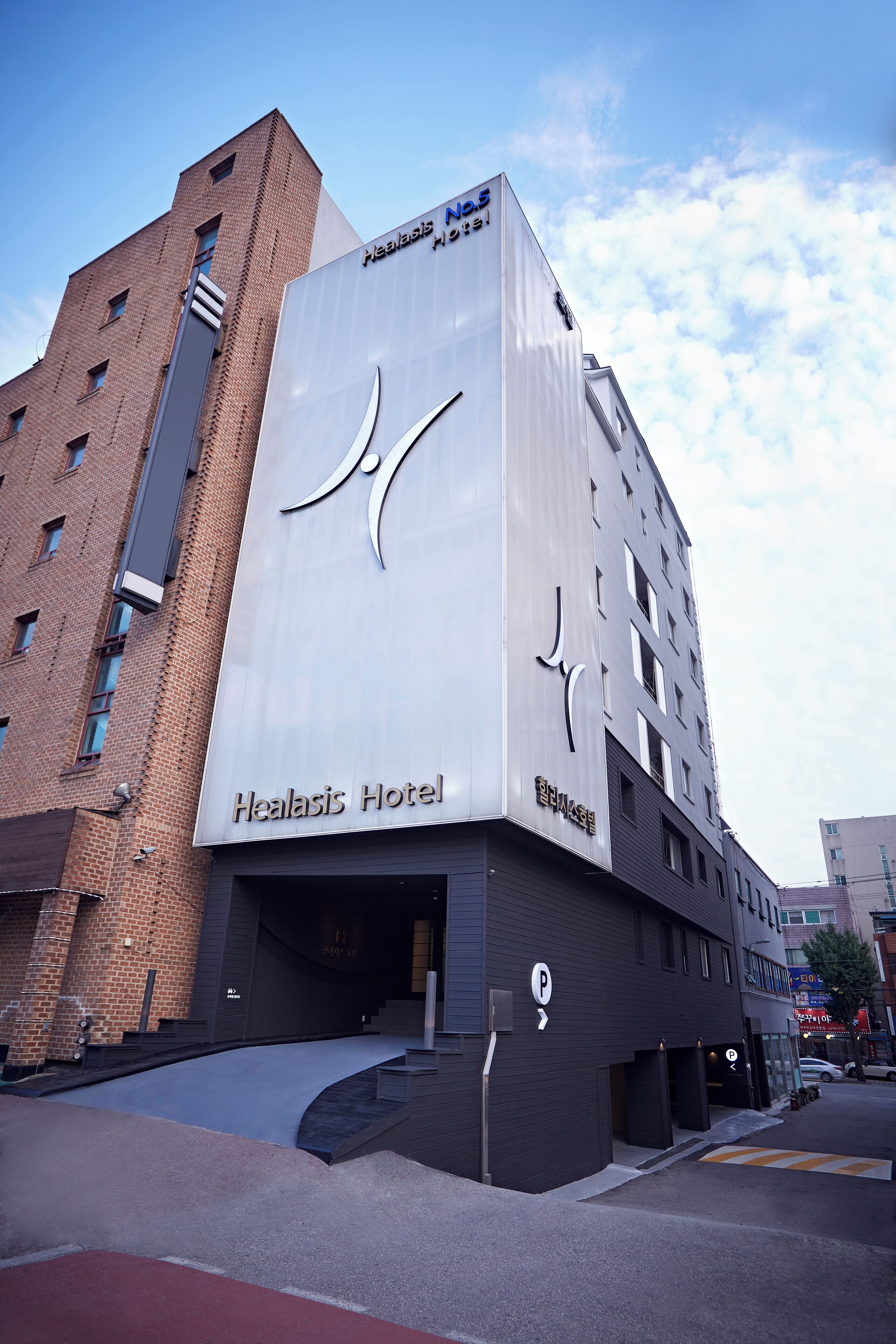 Un edificio moderno con un letrero destacado del Hotel Healasis.