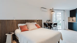 A modern hotel room with a large bed, a desk, and a view of the outdoors. - 101 - Appart'Hôtel Neostelia-Annecy (Annecy)