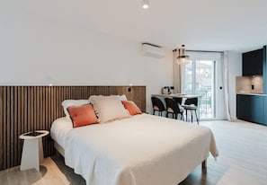 A modern hotel room with a large bed, a desk, and a view of the outdoors. - 101 - Appart'Hôtel Neostelia-Annecy (Annecy)