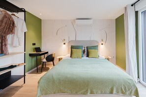 A modern bedroom with a large bed, green walls, a desk, and a chair. - 103 - Appart'Hôtel Neostelia-Annecy (Annecy)