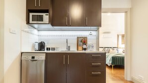 A compact kitchen with a dishwasher, microwave, and a sink. - Pet-friendly guesthouse with garden and playground (Ivanhoe)