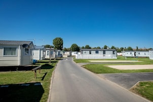 Uma fileira de casas móveis com uma estrada pavimentada no meio.
