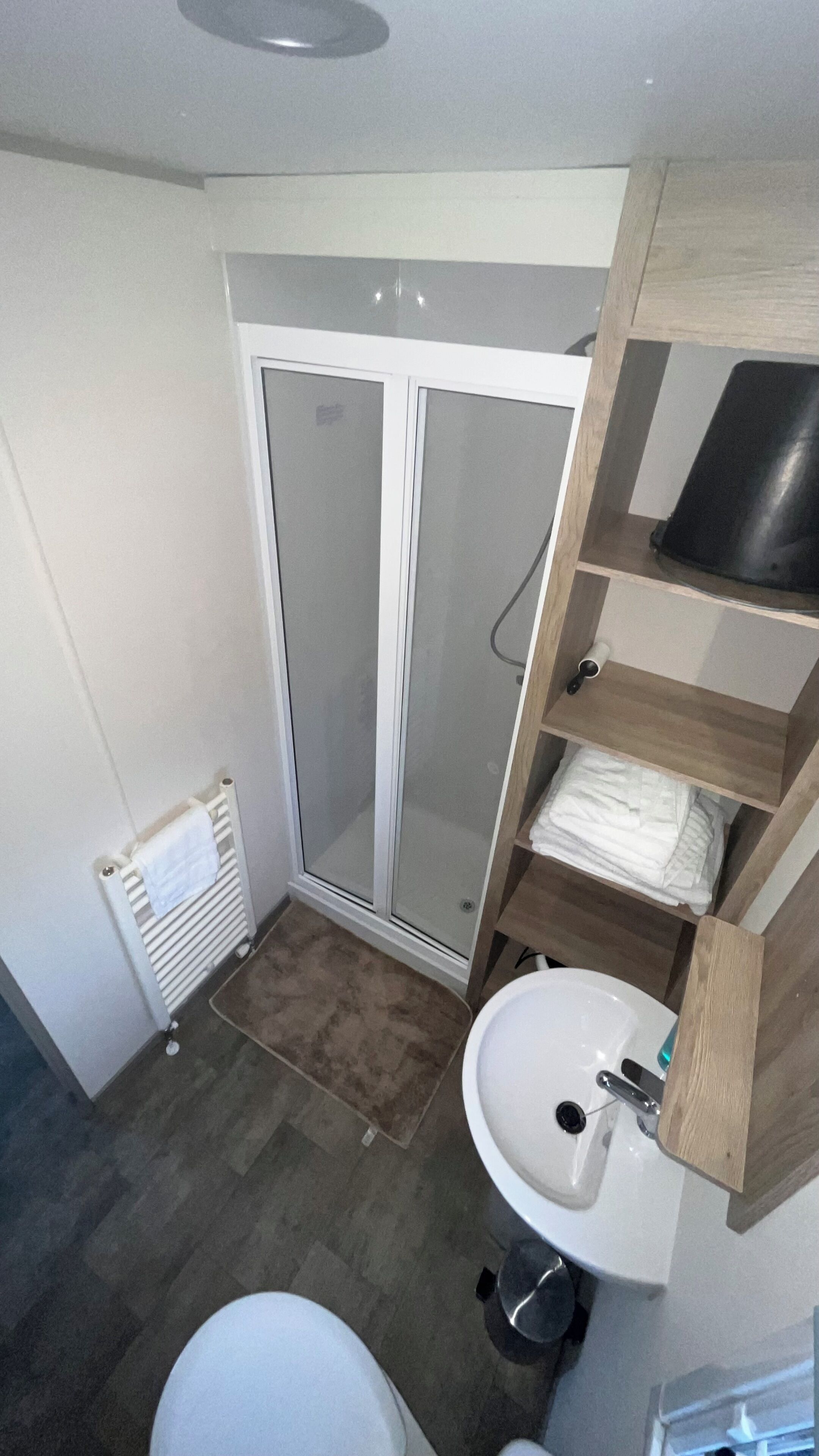Ein kleines Badezimmer mit Duschkabine, Waschbecken und Toilette.