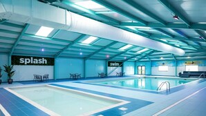 An indoor swimming pool with clear signage for 'splash' and 'swim' areas, surrounded by blue-tiled flooring and equipped with seating and a ladder. - Rc 39 (Felixstowe)