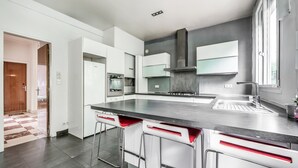 Una cocina moderna con una isla central, electrodomésticos de acero inoxidable y un ventanal amplio.