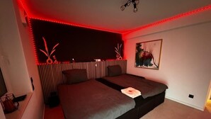 A bedroom with a bed, a nightstand, a wall-mounted shelf, and a painting. - Rheinmosel Glück Wellness (Koblenz)