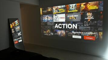 Eine Wand mit einer Projektion verschiedener Filmplakate und dem deutlich sichtbaren Wort "ACTION".