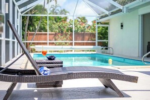 Ein Poolbereich mit Liegestühlen und einer gläsernen Struktur.