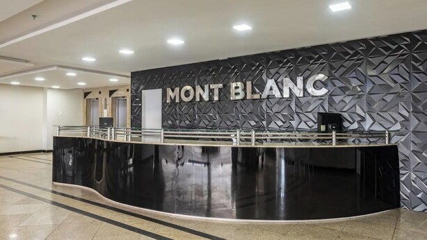 Ein moderner Empfangstresen mit Schwarz-Weiß-Design, über dem der Name "MONT BLANC" gut sichtbar angebracht ist.