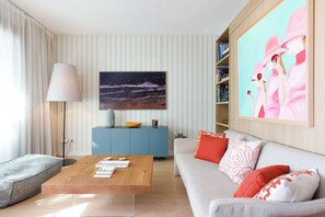 A living room with a sofa, coffee table, and a painting of a night scene.