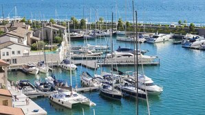Een jachthaven met verschillende boten afgemeerd, een promenade langs het water en woongebouwen.