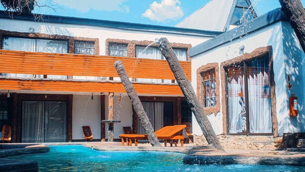 Ein Poolbereich mit Holzliegen und einer Steinstruktur.