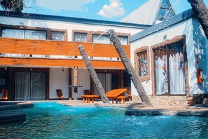 Ett poolområde med träbänkar och en stenkonstruktion.