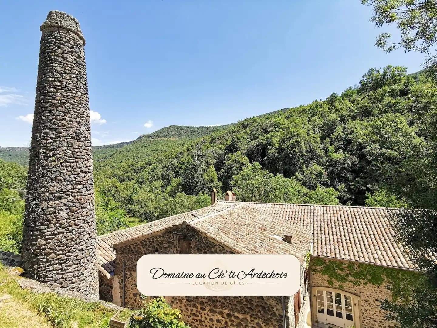 A stone tower and a building with a tiled roof in a rural setting.