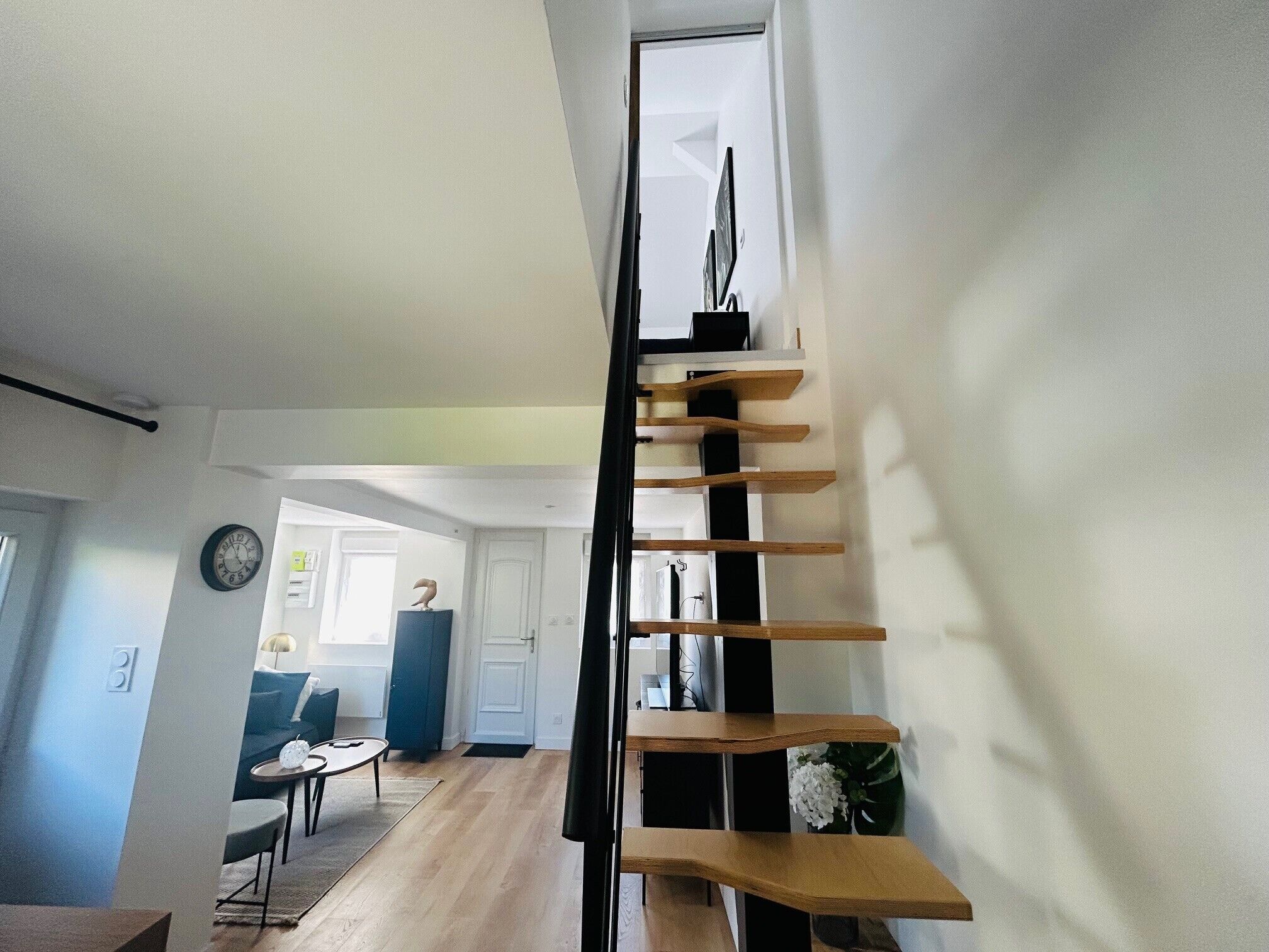 A modern interior with a staircase, a dining area, and a living room.