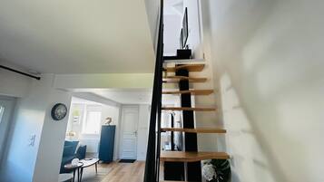 A modern interior with a staircase, a dining area, and a living room.