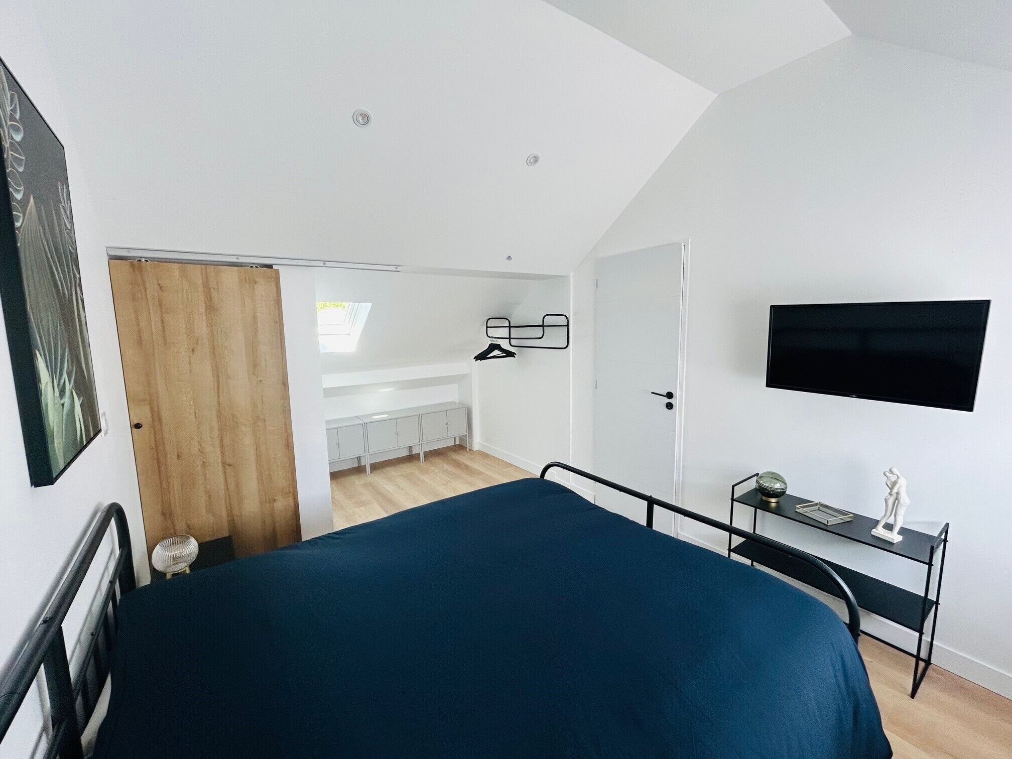 Une chambre à coucher avec un lit, un bureau, une télévision et une armoire.