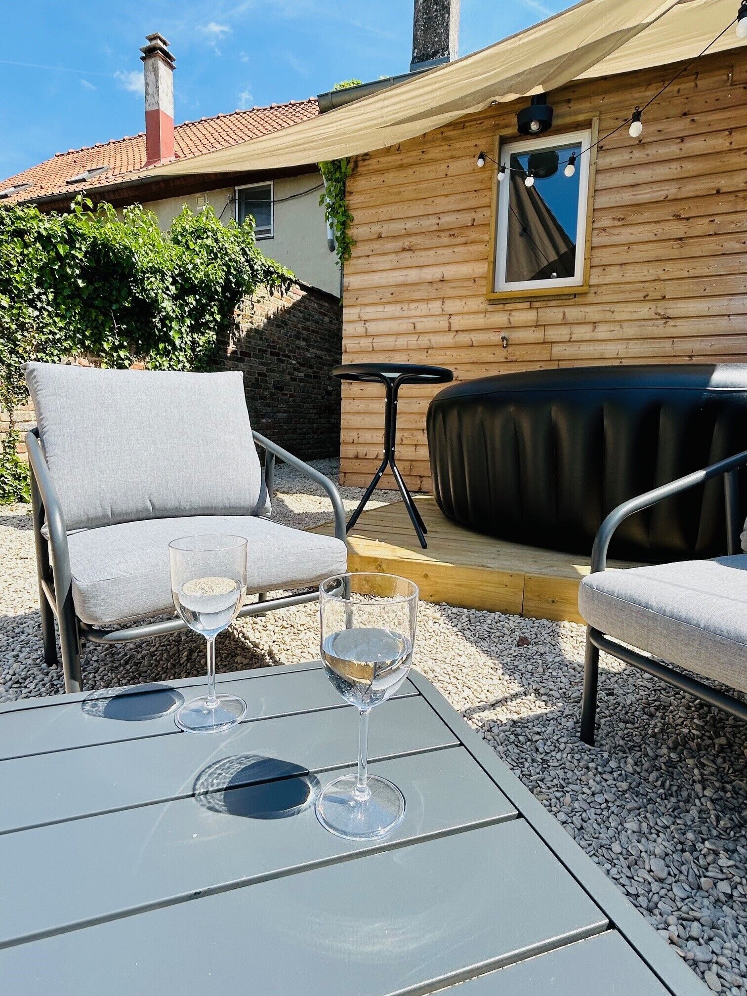 Een terras met twee stoelen, een tafel en een klein krukje.