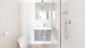 Une salle de bain moderne équipée de toilettes, d’un lavabo et d’une douche.