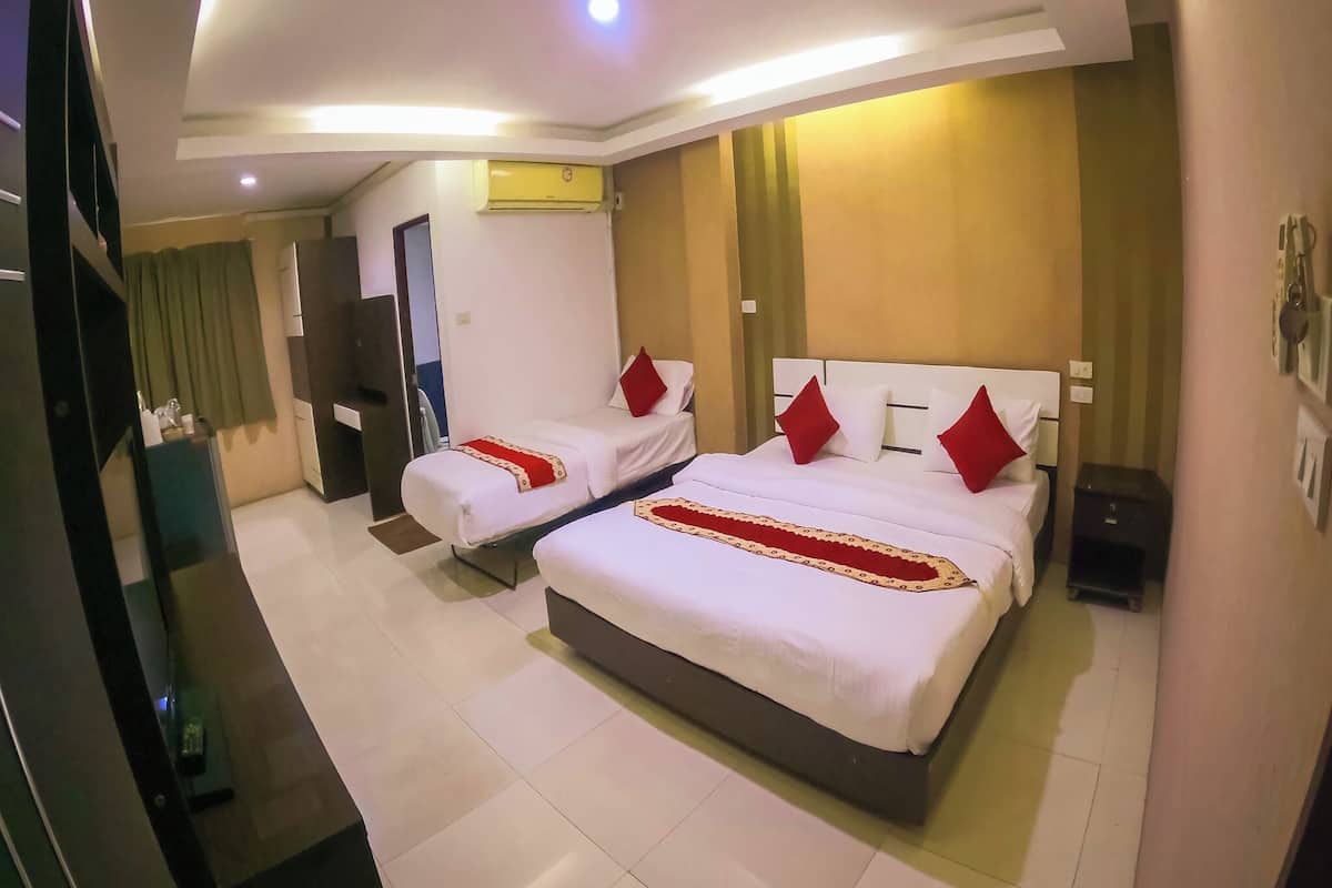 A hotel room with two beds, a flat-screen TV, a minibar, and a ceiling light.