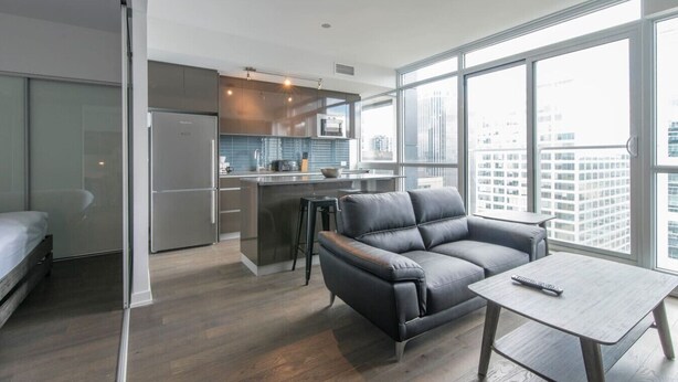 Un apartamento moderno con cocina, sofá y mesa de comedor.